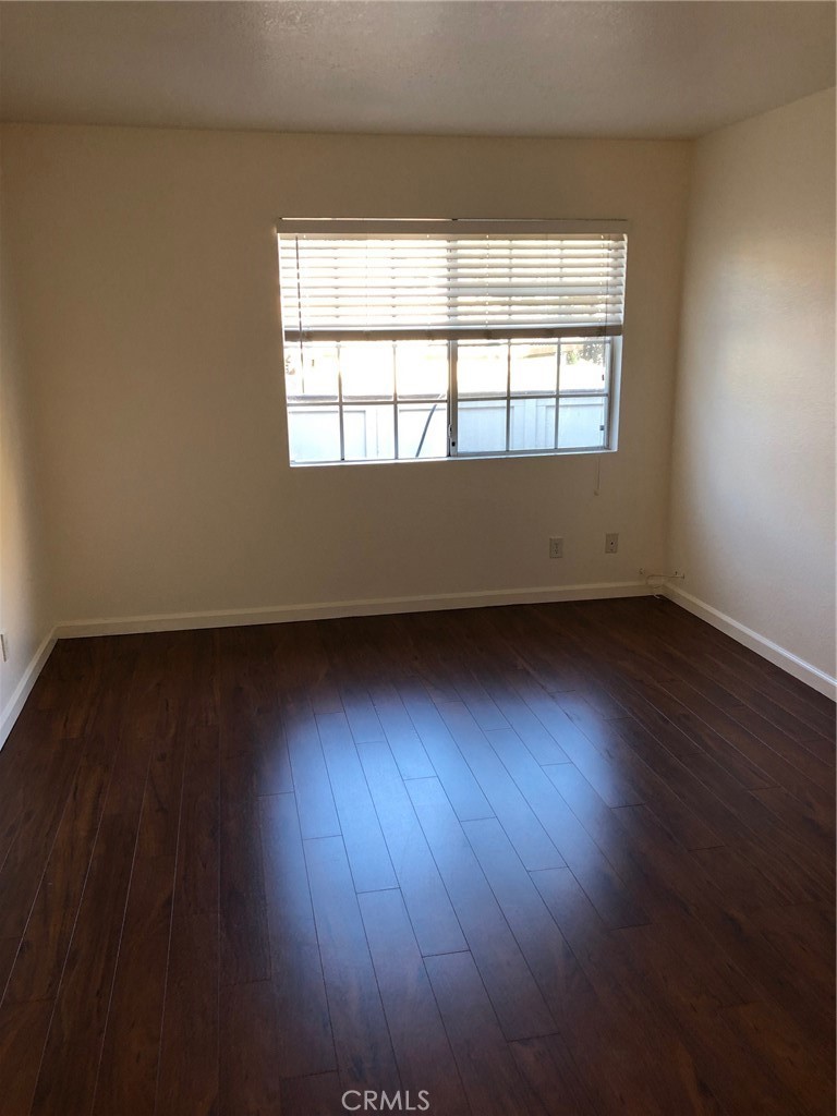 12584 Atwood Court, Unit 1824 Rancho Cucamonga, CA 91739 - Photo 6 of 15 an empty room with wooden floor and windows