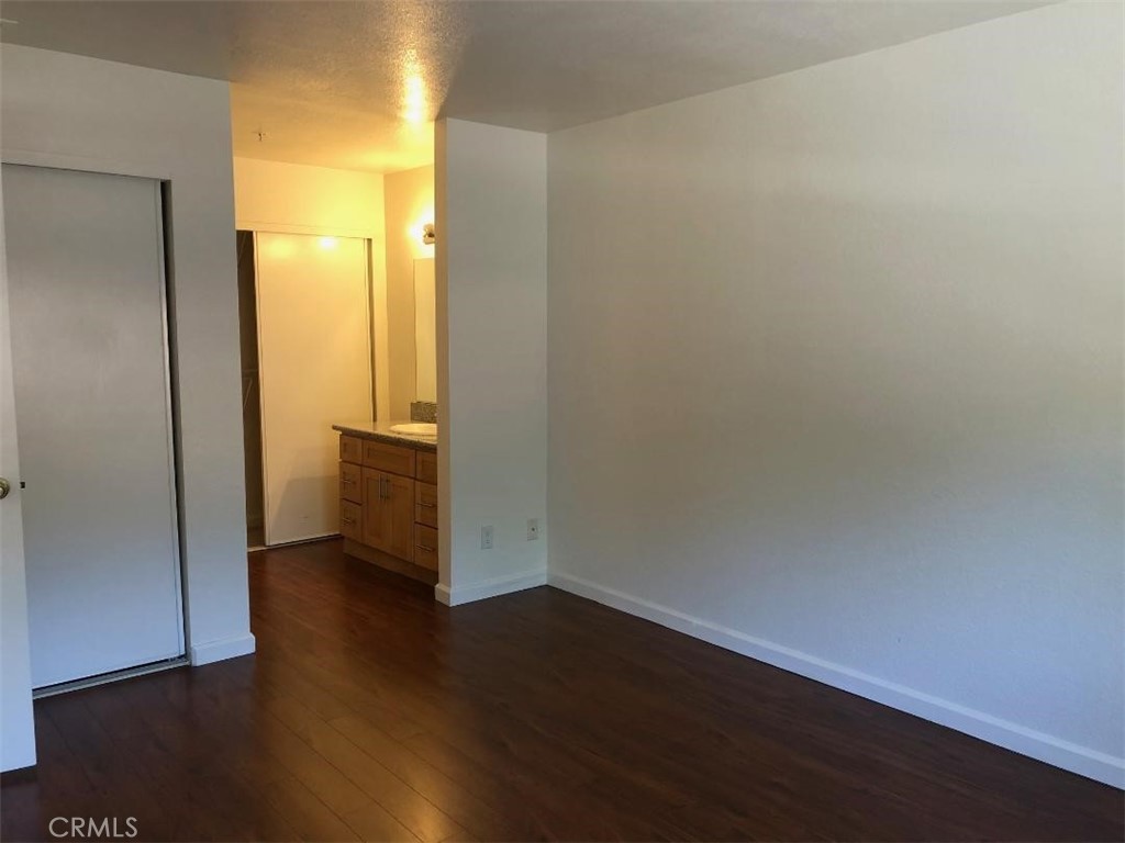 12584 Atwood Court, Unit 1824 Rancho Cucamonga, CA 91739 - Photo 7 of 15 an empty room with wooden floor and windows