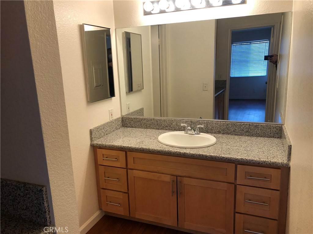 12584 Atwood Court, Unit 1824 Rancho Cucamonga, CA 91739 - Photo 9 of 15 a bathroom with a granite countertop sink and a mirror