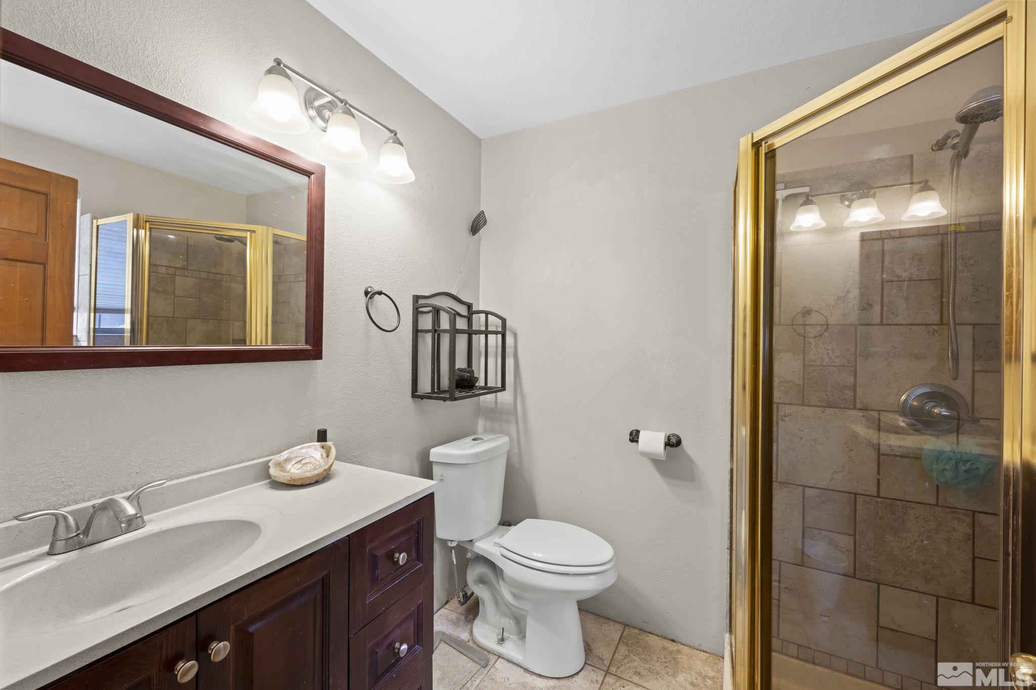 2200 Lousetown Road Reno, NV 89521 - Photo 17 of 40 a bathroom with a granite countertop sink toilet and shower