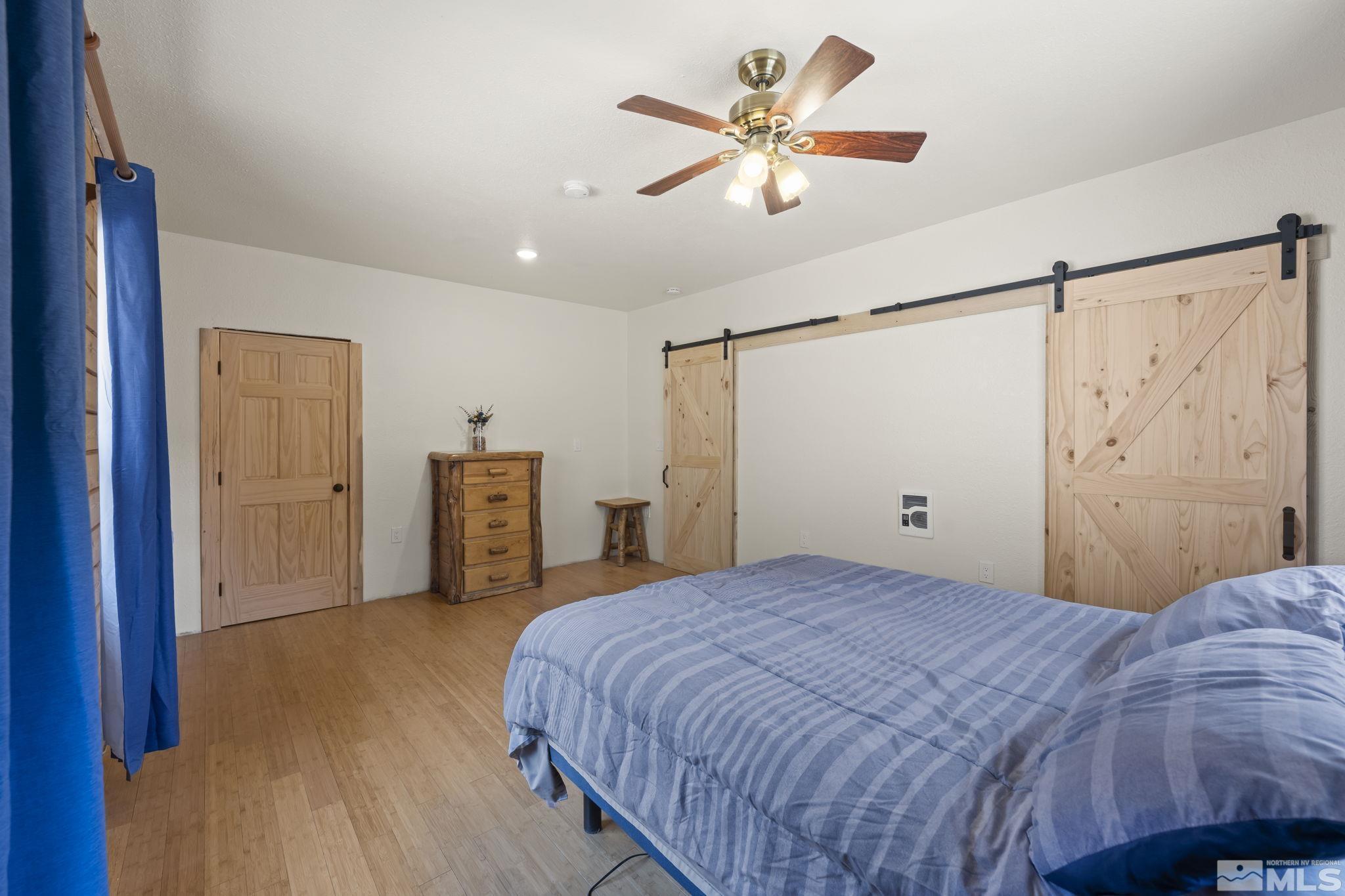 2200 Lousetown Road Reno, NV 89521 - Photo 9 of 40 a bedroom with a large bed and a chandelier