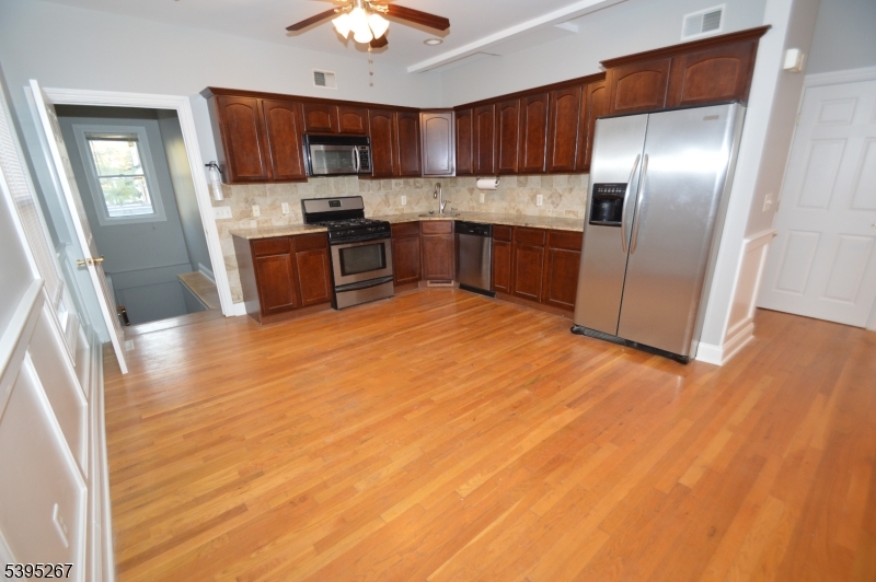 139 Forest Street, Unit 1 Montclair, NJ 07042 - Photo 2 of 23 a kitchen with stainless steel appliances granite countertop a refrigerator a sink a stove with wooden floors