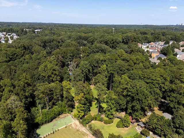 an aerial view of a residential houses covered in trees