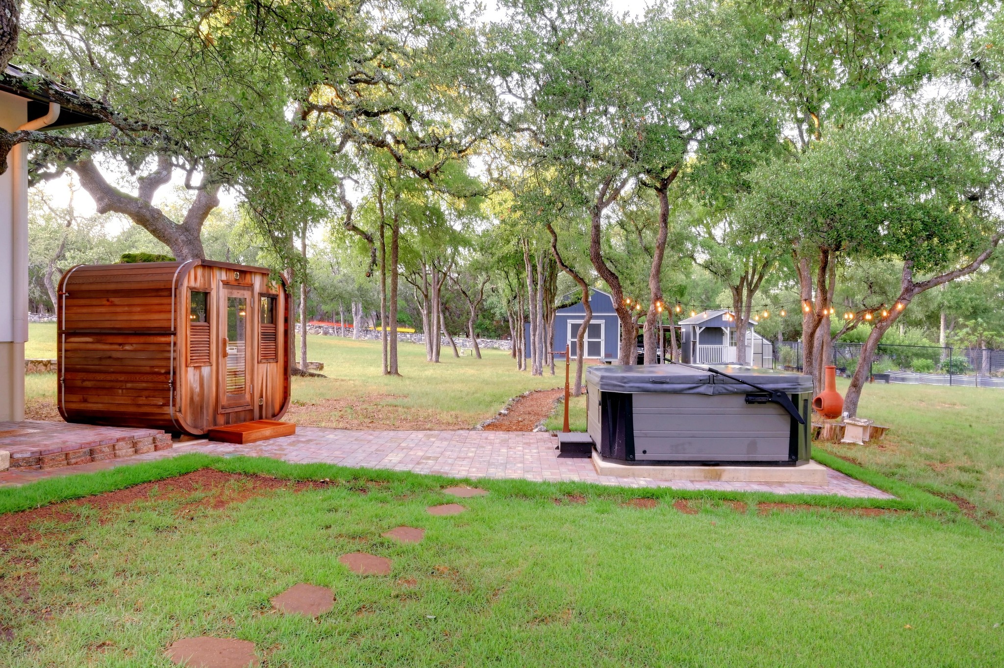 401 Trail Ridge Road Wimberley, TX 78676 - Photo 22 of 34 View of grassy yard featuring a shed, a hot tub, and view of wooded area