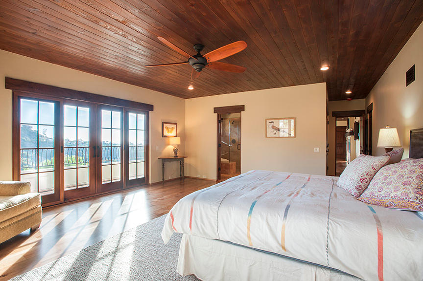 20 Alisal Road Santa Barbara, CA 93103 - Photo 23 of 32 a spacious bedroom with a large bed and a chandelier