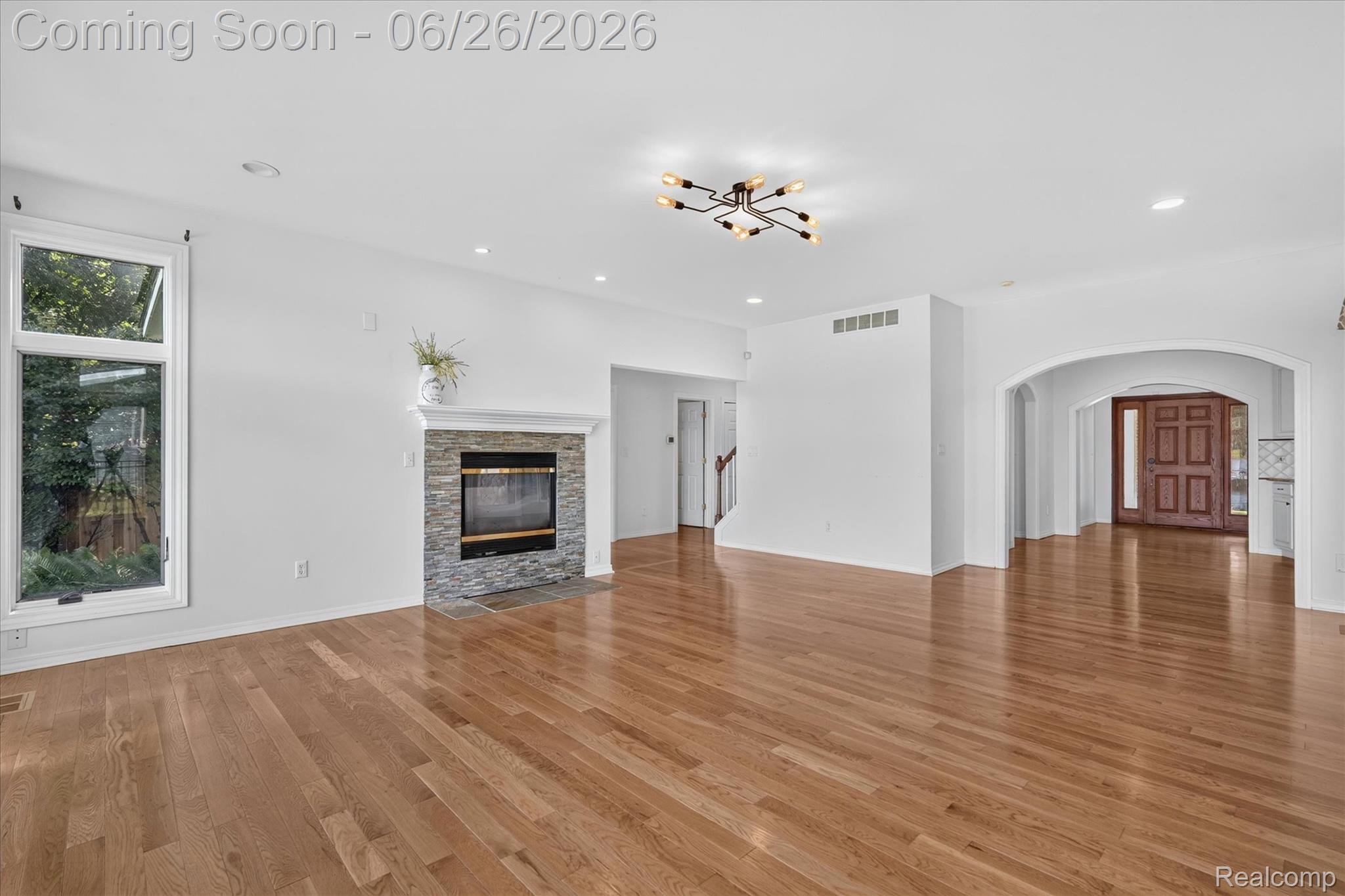 3478 Lexington Road Waterford, MI 48328 - Photo 5 of 52 Expansive living space featuring wood-finish flooring and a stone-clad fireplace with a decorative mantel