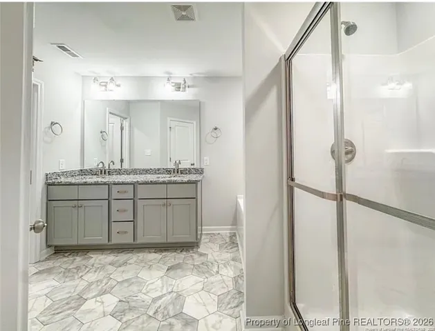 a bathroom with a granite countertop sink a mirror and a shower