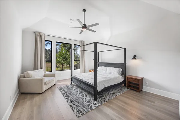 a bedroom with a bed wooden floor and window