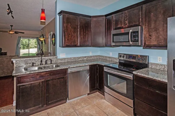 a kitchen that has a sink stove top oven and cabinets