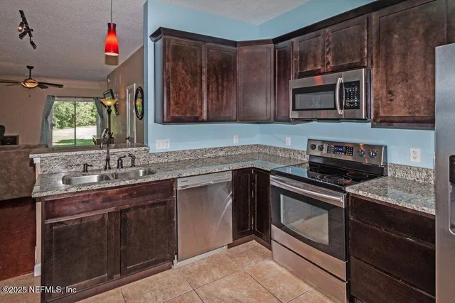 a kitchen that has a sink stove top oven and cabinets