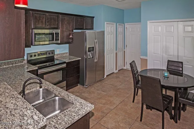 a kitchen with a table chairs refrigerator and microwave