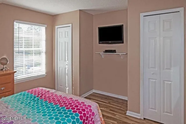 a bedroom with a bed and a flat screen tv