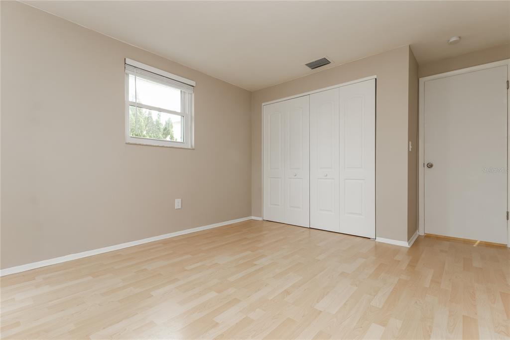 4153 Woodtrail Boulevard New Port Richey, FL 34653 - Photo 13 of 16 a view of an empty room with wooden floor and a window