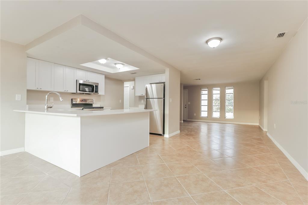 4153 Woodtrail Boulevard New Port Richey, FL 34653 - Photo 4 of 16 a view of kitchen with cabinets and window