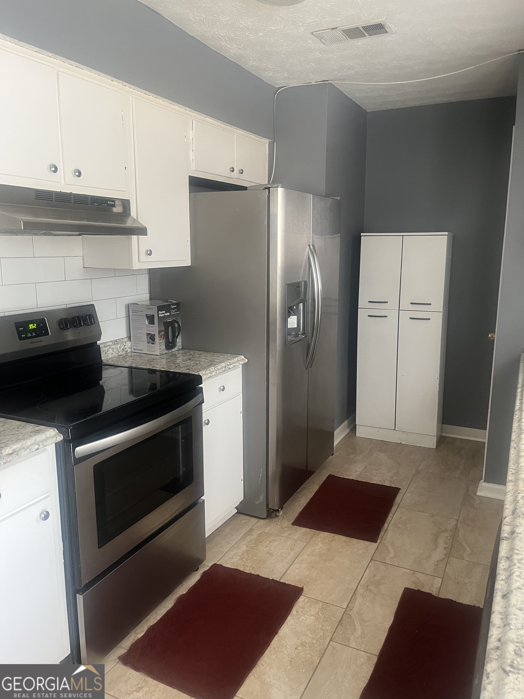 7013 Fielder Road Rex, GA 30273 - Photo 7 of 8 a kitchen with a refrigerator sink and cabinets