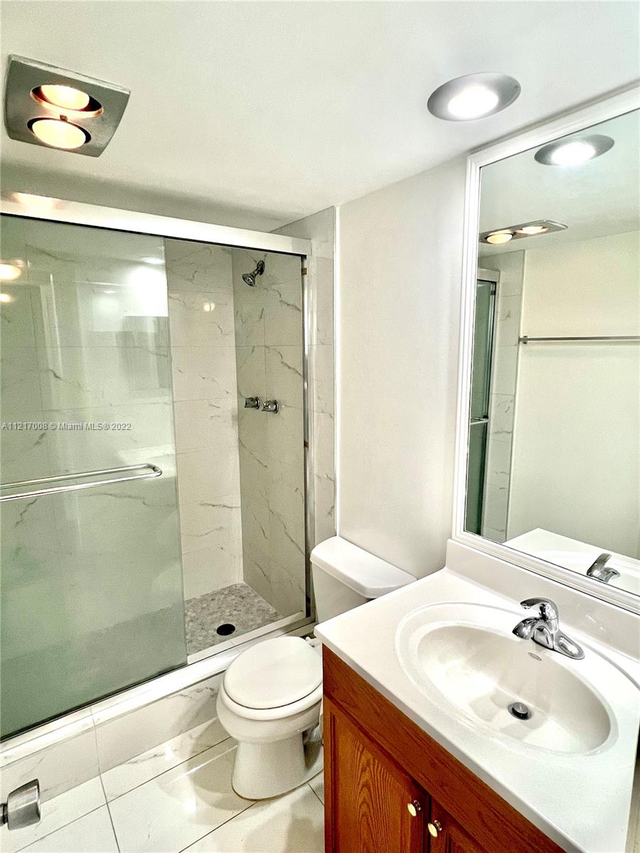 3150 North Course Lane, Unit 107 Pompano Beach, FL 33069 - Photo 11 of 24 a bathroom with a sink a toilet and shower