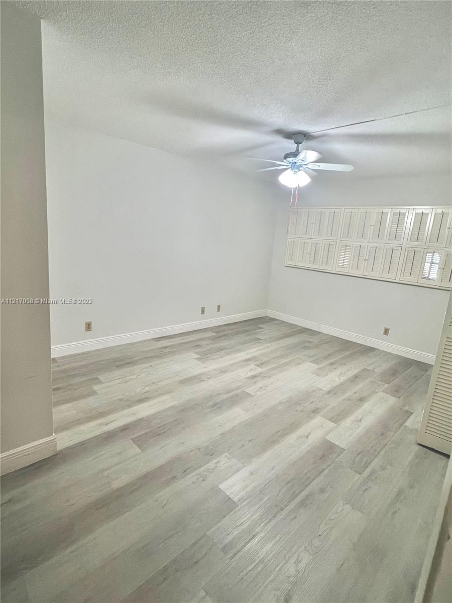 3150 North Course Lane, Unit 107 Pompano Beach, FL 33069 - Photo 15 of 24 en empty room with white walls and fan