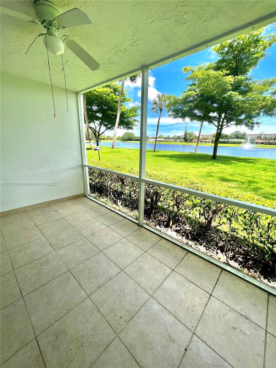 3150 North Course Lane, Unit 107 Pompano Beach, FL 33069 - Photo 2 of 24 an empty room with floor to ceiling windows and yard