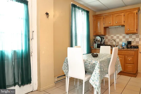 a dining room with furniture a window and kitchen