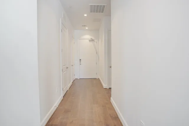 a view of a hallway with wooden floor