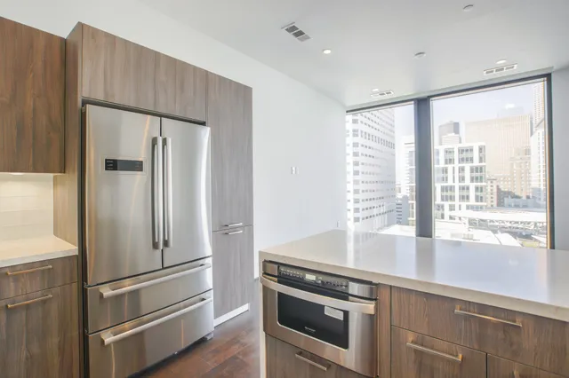 a metallic refrigerator freezer sitting inside of a kitchen