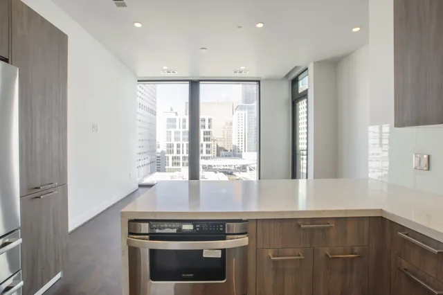 a kitchen with stainless steel appliances granite countertop a stove a sink and a microwave