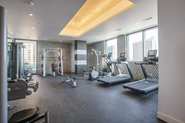 a room with gym equipment and large windows