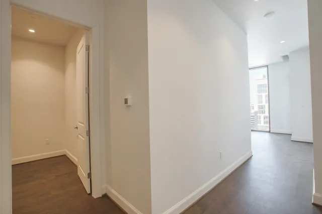 a view of a hallway with wooden floor