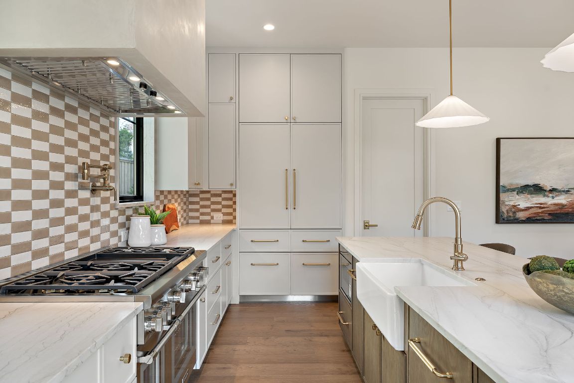 2705 Warren Street Austin, TX 78703 - Photo 14 of 39 a kitchen with white cabinets a sink stove and refrigerator