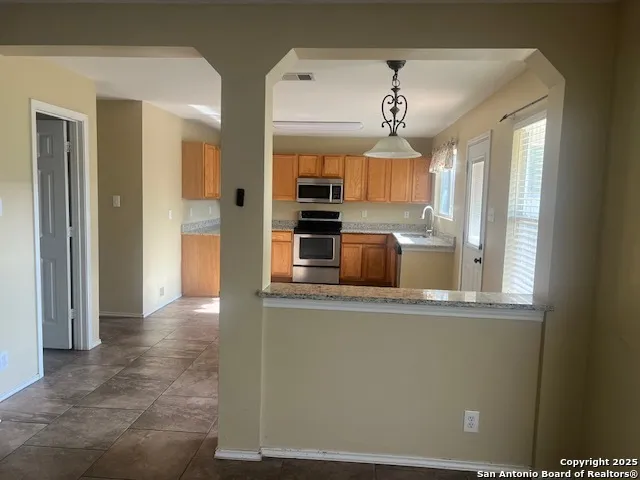 a kitchen with stainless steel appliances granite countertop a stove sink and cabinets