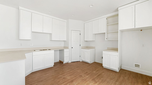717 South Harrison Drive West Springville, UT 84663 - Photo 4 of 31 Kitchen featuring white cabinetry, light-toned countertops, wood-finish flooring, and a built-in pantry door