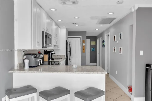 a kitchen with stainless steel appliances granite countertop a refrigerator and a sink