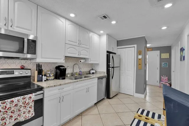 a kitchen with stainless steel appliances granite countertop a refrigerator sink and stove