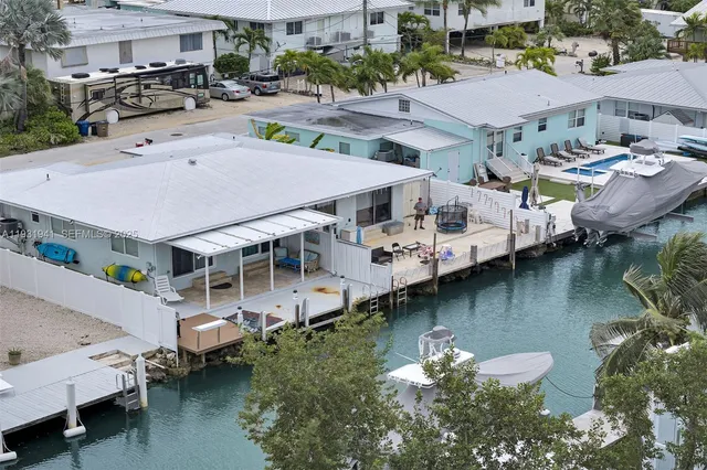 an aerial view of a house with swimming pool and a yard