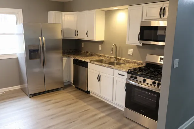 a kitchen with stainless steel appliances granite countertop a stove a refrigerator and a microwave