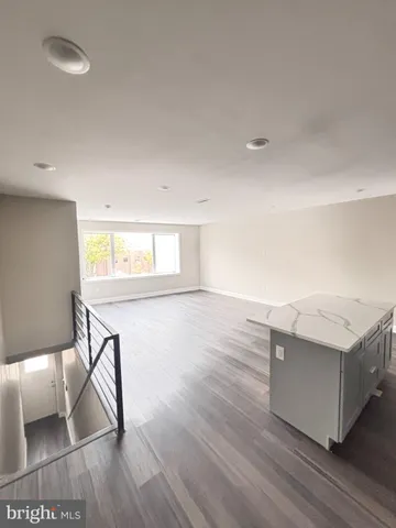 a kitchen with granite countertop a stove and a wooden floors