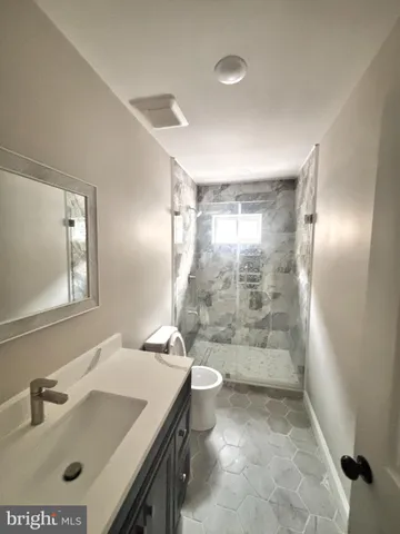 a bathroom with a sink shower and a mirror