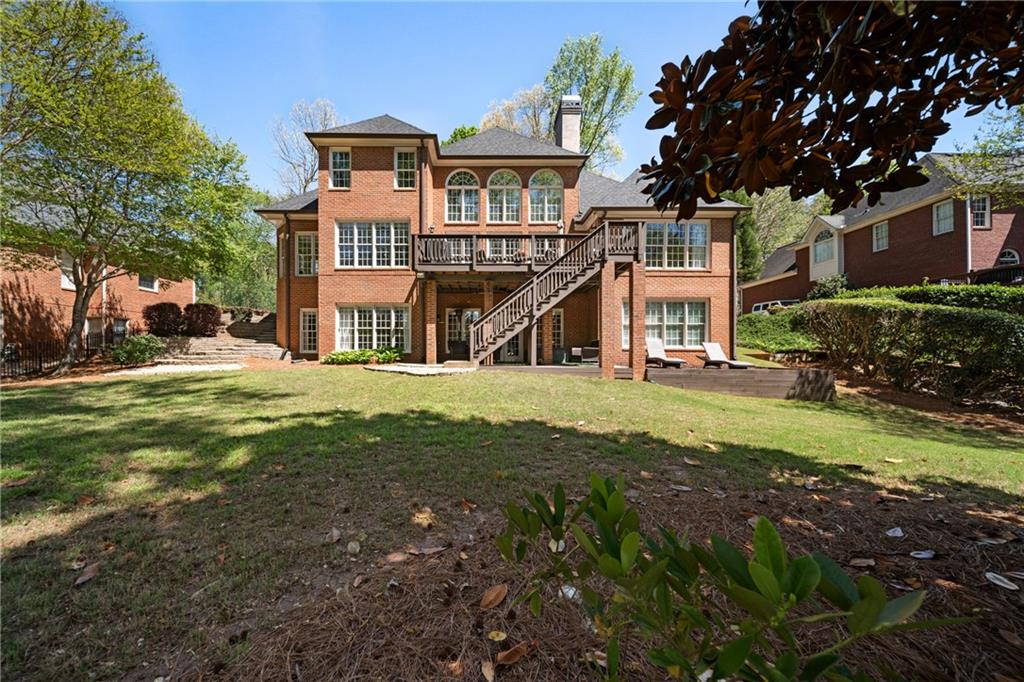 7105 Sheffield Place Cumming, GA 30040 - Photo 39 of 73 a view of a big house with a big yard and large trees