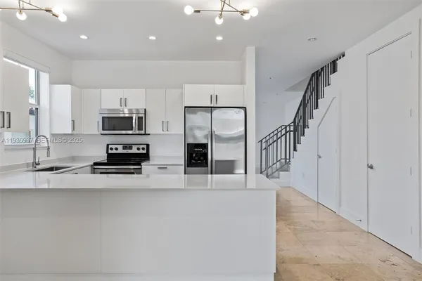 a kitchen with stainless steel appliances a refrigerator and a stove top oven