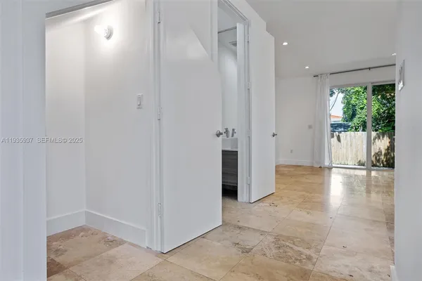 an empty room with large windows and garden