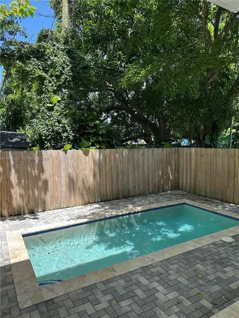 a view of a house with a yard and a large tree