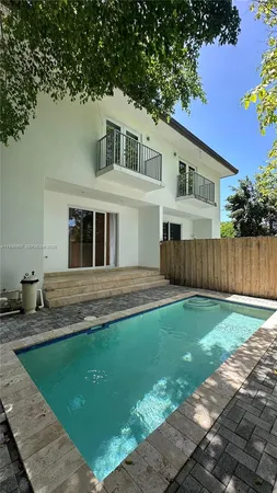 a view of backyard with swimming pool and wooden fence