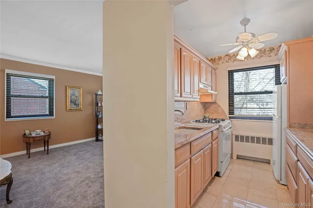 a kitchen with stainless steel appliances granite countertop a stove top oven a sink a dining table and chairs with wooden floor