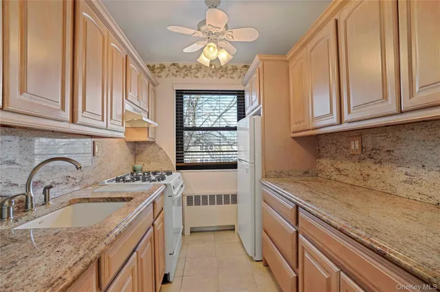 a kitchen with granite countertop a sink stainless steel appliances and cabinets