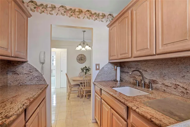 a kitchen with granite countertop a sink a stove and cabinets