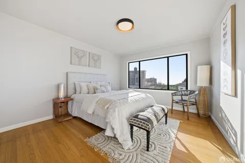 a bedroom with a bed and a painting on the wall