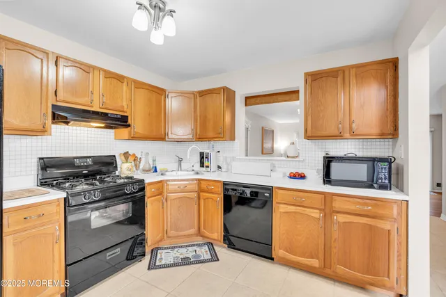 a kitchen with stainless steel appliances granite countertop a stove sink microwave and cabinets