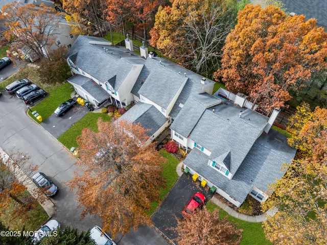 an aerial view of a house with a yard and a large tree