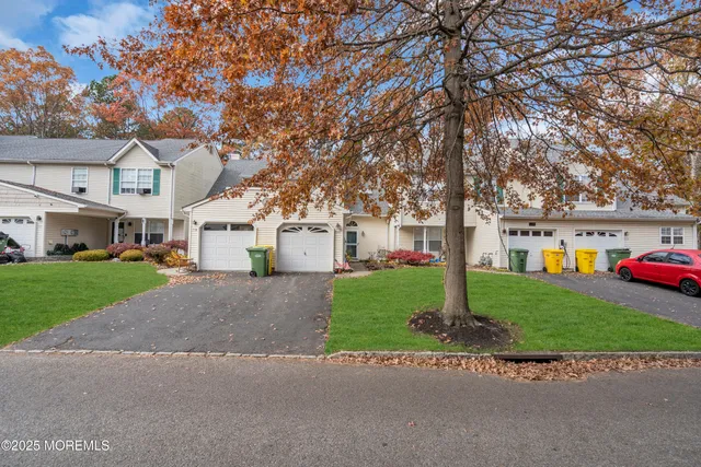 a view of a white house next to a yard and a road