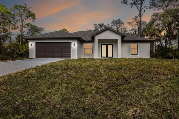 a front view of a house with a yard and garage
